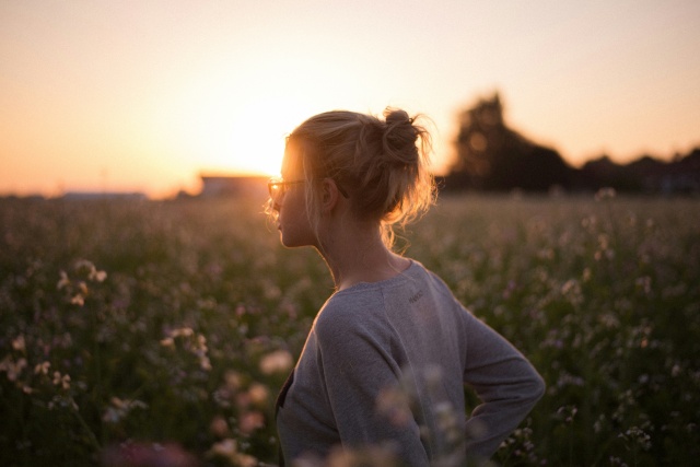 夕日のなかに佇む女性