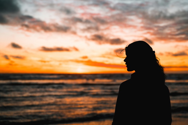 夕日を眺める女性のシルエット