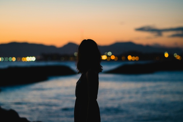 海辺に佇む一人の女性